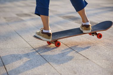 Kaykaycı şehir dışında kaykay yapıyor.