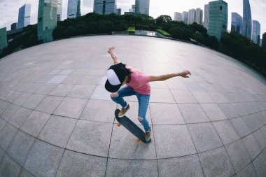 Kaykaycı şehir dışında kaykay yapıyor.