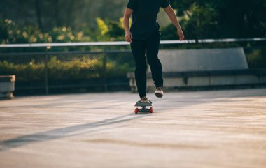 Kaykaycı şehir dışında kaykay yapıyor.