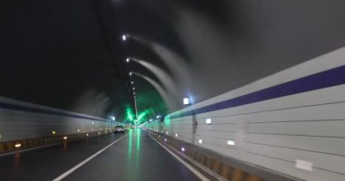 Yeraltı tünelinde ışıklarla giden araba.