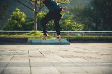 Kaykaycı şehir dışında kaykay yapıyor.