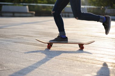 Kaykaycı şehir dışında kaykay yapıyor.