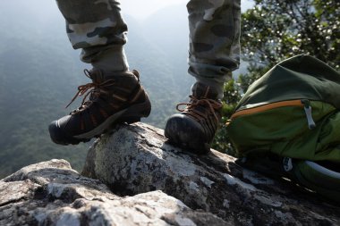Başarılı yürüyüşçü dağın tepesindeki manzaranın tadını çıkar.