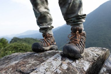 Başarılı yürüyüşçü dağın tepesindeki manzaranın tadını çıkar.