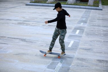 Kaykaycı şehir dışında kaykay yapıyor.