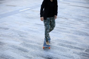 Kaykaycı şehir dışında kaykay yapıyor.