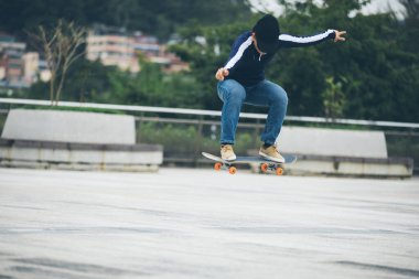 Kaykaycı şehir dışında kaykay yapıyor.