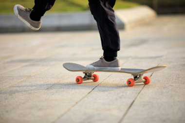 Kaykaycı şehir dışında kaykay yapıyor.