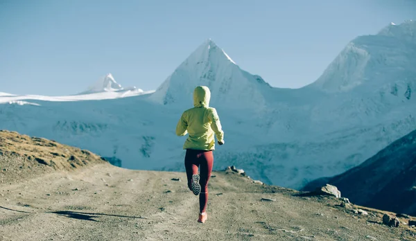 冬の山を走る女トレイルランナー — ストック写真