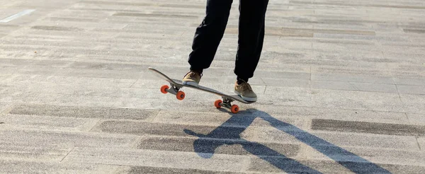 Kaykaycı şehir dışında kaykay yapıyor.