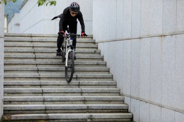 Kadın Freerider şehir merdivenlerinden iniyor.