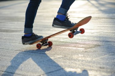 Kaykaycı şehir dışında kaykay yapıyor.