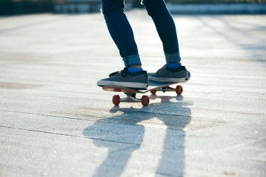 Kaykaycı şehir dışında kaykay yapıyor.