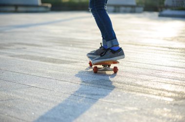 Kaykaycı şehir dışında kaykay yapıyor.