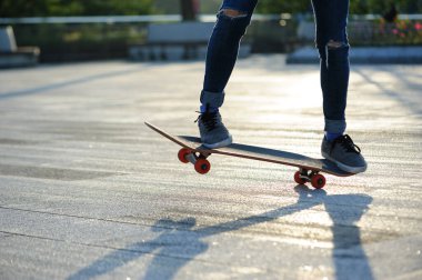 Kaykaycı şehir dışında kaykay yapıyor.