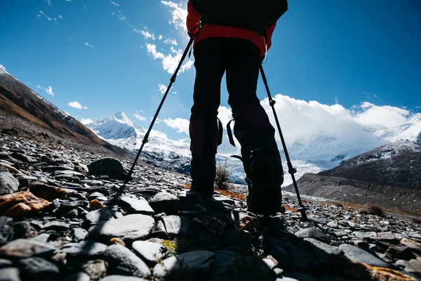 Woman backpacker hiking in winter high altitude mountains