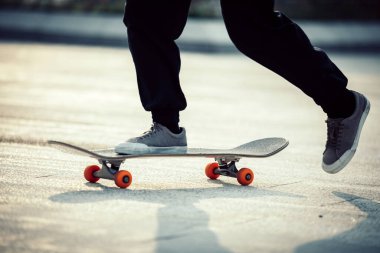 Kaykaycı şehir dışında kaykay yapıyor.