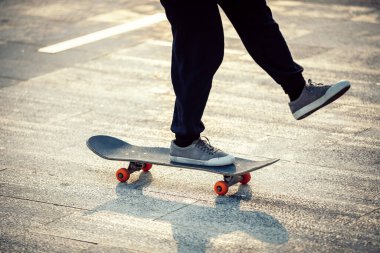 Kaykaycı şehir dışında kaykay yapıyor.