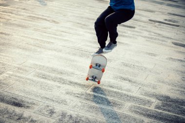 Kaykaycı şehir dışında kaykay yapıyor.