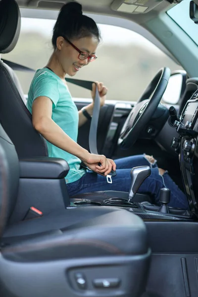 女性ドライバーは運転する前にシートベルトをバックルアップ — ストック写真