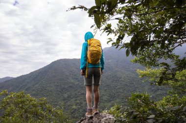 Başarılı yürüyüşçü dağın tepesindeki manzaranın tadını çıkar.
