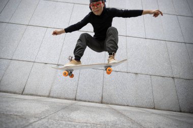 Kaykaycı şehir dışında kaykay yapıyor.