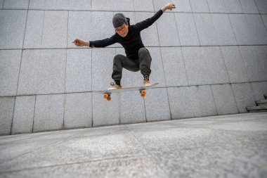 Kaykaycı şehir dışında kaykay yapıyor.