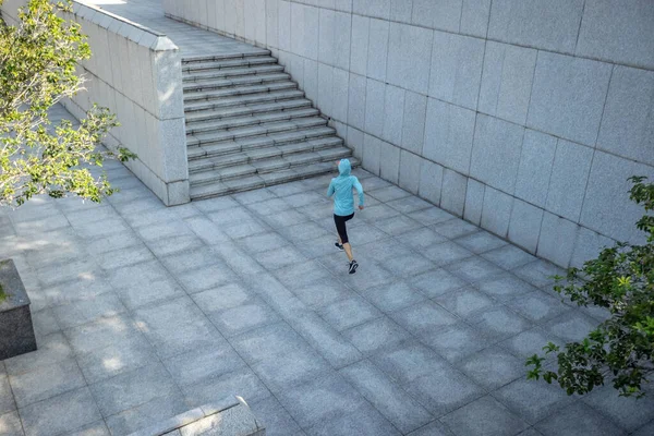 健身女运动员在城市里跑上楼去 — 图库照片