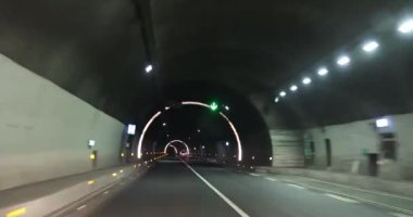 Yeraltı tünelinde ışıklarla giden araba.