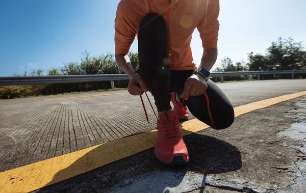 Kış dağlarında koşan bağcık bağlayan kadın koşucu.