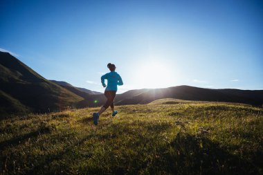Dağın zirvesinde koşan kadın ultra maraton koşucusu