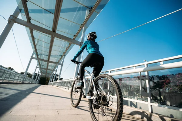 阳光明媚的日子 女人在城市骑自行车 — 图库照片