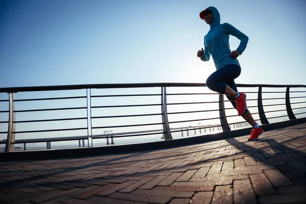 海辺の橋の上を走るフィットネス女性ランナー — ストック写真