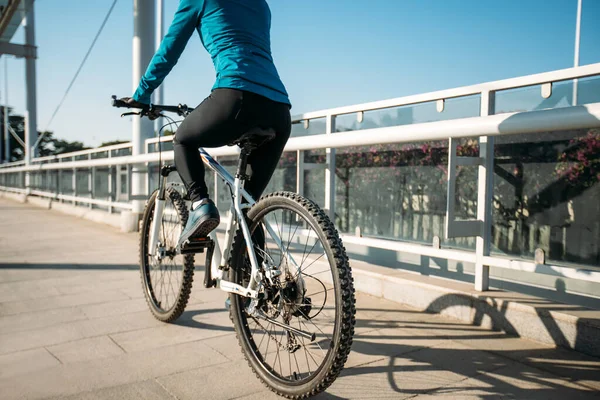 阳光明媚的日子 女人在城市骑自行车 — 图库照片