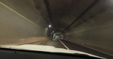 Yeraltı tünelinde ışıklarla giden araba.