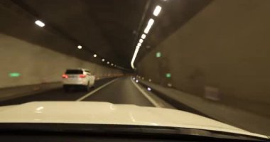 Yeraltı tünelinde ışıklarla giden araba.