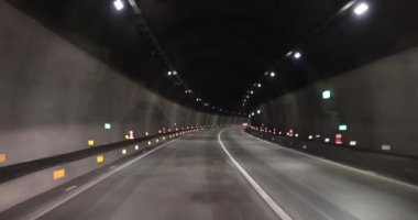 Yeraltı tünelinde ışıklarla giden araba.