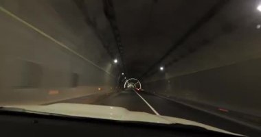 Yeraltı tünelinde ışıklarla giden araba.