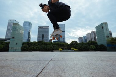 Kaykaycı şehir dışında kaykay yapıyor.