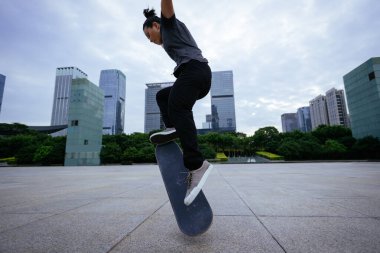 Kaykaycı şehir dışında kaykay yapıyor.