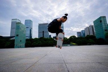 Kaykaycı şehir dışında kaykay yapıyor.