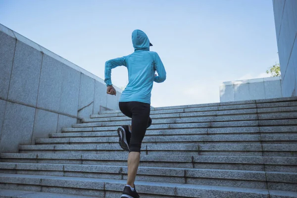 Fitness sporcusu kadın şehirde merdivenleri koşarak çıkıyor.