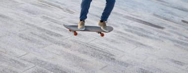 Kaykaycı şehir dışında kaykay yapıyor.