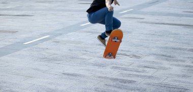 Kaykaycı şehir dışında kaykay yapıyor.