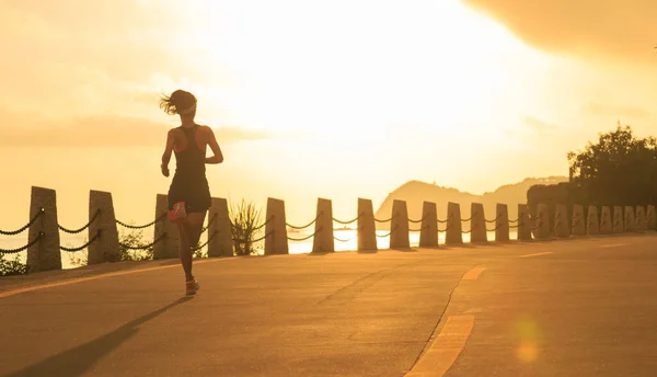 女子赛跑选手在日出海滨奔跑 — 图库照片