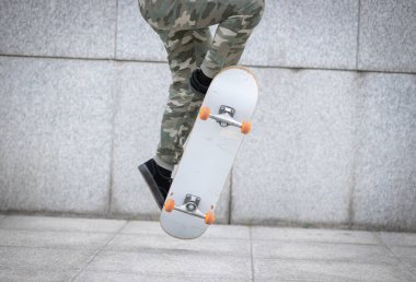 Kaykaycı şehir dışında kaykay yapıyor.