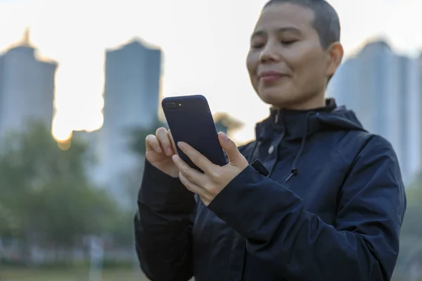 Focused Bald Woman Using Cellphone City — Zdjęcie stockowe