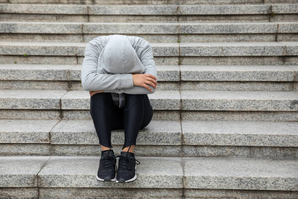Upset woman sitting alone in city stairs