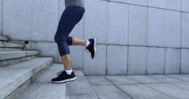 Fitness kadını şehirde merdivenleri koşarak çıkıyor.