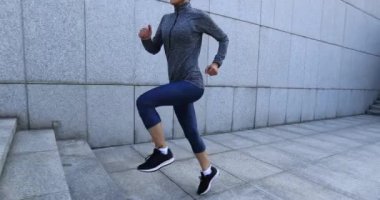 Fitness kadını şehirde merdivenleri koşarak çıkıyor.